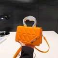 Quilted crossbody bag in vibrant orange featuring a stylish silver geometric handle - Orange