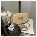Detail of a beige leather crossbody bag featuring a vintage silver bow metal buckle - Khaki