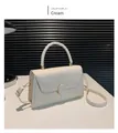 Elegante borsa a tracolla bianco crema con fibbia dorata e manico rigido in set da studio - Bianco