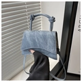 Detail of light blue denim hourglass handbag with knot handle and gold hardware - Sky Blue