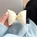 Gros plan sur un nœud en similicuir crème avec rembourrage et étiquette tissée design - Clip Arrière Noeud en Cuir - Blanc Crème / Blanc Cassé