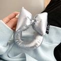 Detail of silver metallic puffy bow charm with woven label on solid leather phone strap - Silver/Silver