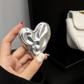 Macro shot of silver liquid metal heart phone grip with reflective mirror finish texture - Transparent Stand / Silver