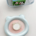 Makroaufnahme von Katzen-Acrylspiegel auf einem hellblauen Bären-Keramiktablett - Muschel-Textur Katzen-Spiegel - Cremeweiß