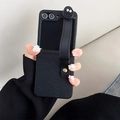 Detail view of leather folding phone case with wrist strap and cute cartoon character - Samsung ZFlip3 / Black