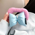 Close-up of pink padded tube and blue bow strap detail on a premium leather phone case - Pink and Blue