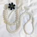Close-up of a multilayer pearl phone lanyard with a black flower charm and silver clip - Heart Large Flower Back Clip + Pearl Chain Set (Black)