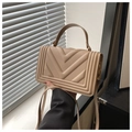 Detailed view of beige quilted handbag featuring a V-stitch flap and textured leather finish - Khaki