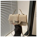 Detail of cream leather shoulder bag featuring silver buckle and wrinkled texture finish - White