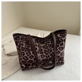 Primer plano de bolso tote con estampado de leopardo, asas de cuero y logo de marca - Caqui