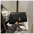 Detalle de bolso de hombro en cuero negro con cierre giratorio dorado de diseño sobrio - Negro