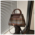 Detail of vintage plaid crossbody bag with brown handle and leather strap textures - Coffee