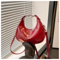 Close-up of red glossy leather hobo bag with adjustable strap and metal hardware - Red