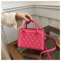 Detail der rosapinkfarbenen kleinen Tasche mit herzförmiger Rautenstickerei und Handgriff - Rosa