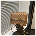Dettaglio della borsa trapuntata beige con tracolla a catena dorata e fibbia in metallo - Cachi