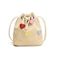 Beige Kordelzug-Beuteltasche mit bunten Lederherz-Patches und schmalem Schultergurt - Gebrochenes Weiß
