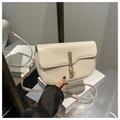 Detalle de bolso silla de montar crema minimalista con cierre dorado y piel mate - Blanco