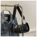 Detail of black leather underarm bag featuring silver rivets and wide strap decoration - Black