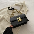 Borsa a tracolla nera con fibbia dorata e cinturino a catena su una giacca blazer - Nero