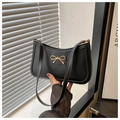 Detalle de bolso de hombro en cuero negro con hebilla de lazo dorado y correa delgada - Negro