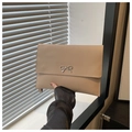 Detail of beige envelope clutch bag featuring a silver metal bow and thin strap texture - Khaki