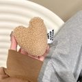 Close-up of plush khaki heart accessory with Never Give Up woven label detail - Brown