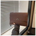 Detail view of dark brown envelope clutch bag with silver bow buckle and wrist strap - Coffee