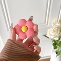 Mano che tiene un supporto per telefono a fiore rosa opaco con centro giallo su rose - Fiore Rosso Rosa Opaco