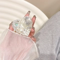 Detailed close-up of a heart-shaped phone grip featuring resin roses, pearls and rhinestones - Gray