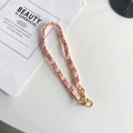 Détail de la chaîne entrelacée de cuir rose clair et métal doré avec mousqueton - Court Portatif / Rose