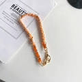 Détail de la chaîne dorée tressée en cuir orange avec fermoirs mousquetons dorés - Court Portatif / Orange