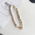 Détail d'une chaîne dorée élégante entrelacée de cuir blanc avec un fermoir mousqueton - Court Portatif / Blanc