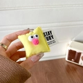 Detailed view of yellow plush phone grip with cartoon big eyes and metal clasp hook - Yellow