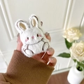 Close-up of cute plush bunny phone socket grip with soft white fur and pink cheek details - Rabbit