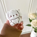 Detailed macro view of cute white plush dog earphone case with pink blush embroidery - Dog