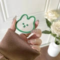 Handheld view of a cute rabbit-shaped grass green phone grip mirror with a smiley face - Dark Green