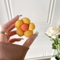 Nahaufnahme der gelben Kord-Blumen-Handyhalterung mit 3D-Struktur und Texturdetails - Gelb