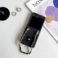 Detalle de funda plegable de cuero negro con correa de cadena dorada y colgante de oso joya - Oso de Diamantes Galvanizado-Cadena Corta / Negro / Samsung Z Fold3