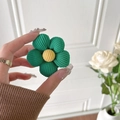 Makro-Detail einer grünen Cord-Blumen-Handyhalterung mit weicher Strickfüllung und Kern - Grün