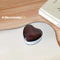 Dettaglio di un supporto per telefono a cuore marrone scuro con finitura lucida - Supporto a Base Bianca / Marrone Grigio