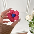 Nahaufnahme der rot-blauen Cord-Strickblume für Handyhalterungen mit gestreifter Textur - Rosarot