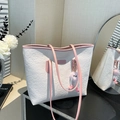 Off-white embossed tote bag with pink straps and plush charm in a lifestyle setting - With Pendant / Pink