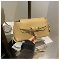 Detail shot of a beige leather shoulder bag with a decorative buckle strap design - Khaki