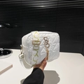 Borsa a tracolla trapuntata bianca con logo dorato e ampia tracolla a fantasia in mano - Bianco