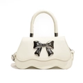 Elegant cream white square handbag with wave edge design and grey metal bow decoration - White