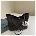 Macro shot of large quilted denim tote bag featuring silver metal closure and plush pendant - With Pendant / Black
