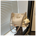 Détail du sac bandoulière texturé gaufré crème avec écusson en cuir Tidal Dryness - Khaki Avec Pendentif