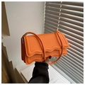 Detail of orange baguette shoulder bag featuring scalloped edges and accordion pleated sides - Orange