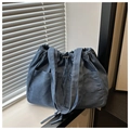 Detail of blue denim tote bag featuring drawstring closure and two front pockets - Blue Denim