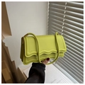 Detail of lime green shoulder bag with scalloped edges and woven texture strap - Green